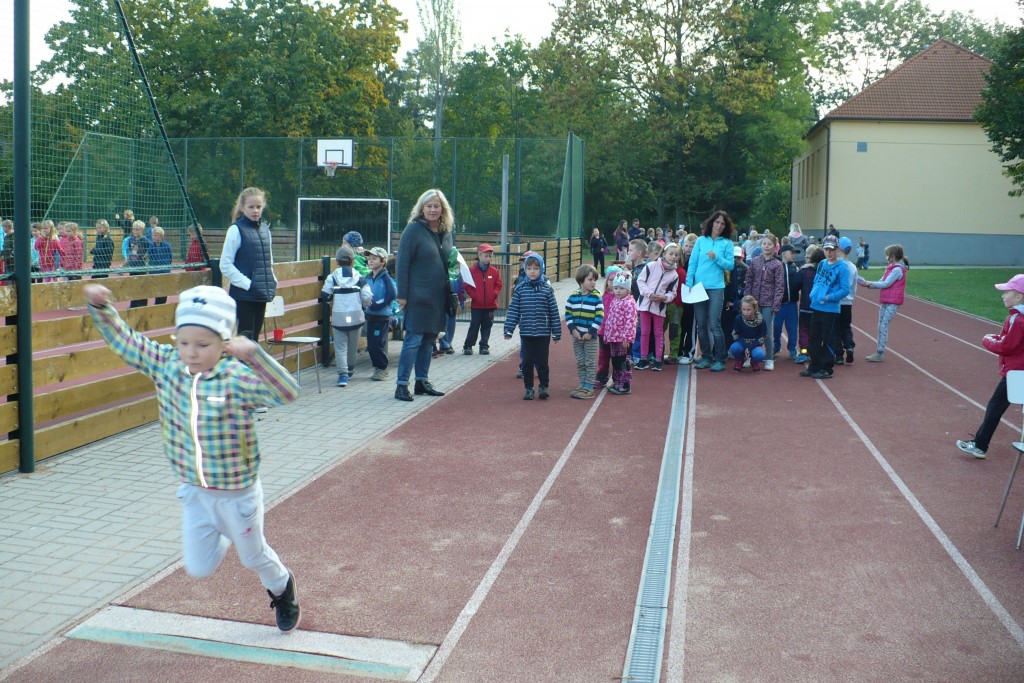 Děti sportují na venkovním hřišti.