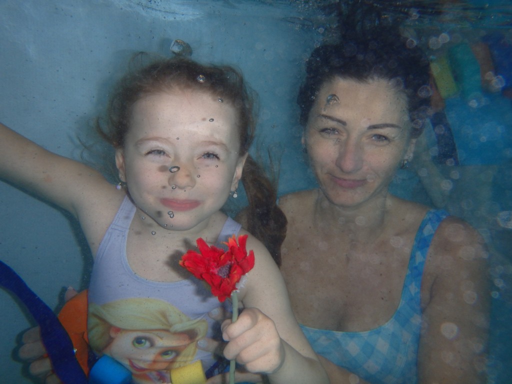 Holčička s lektorkou vyfocené pod vodou.