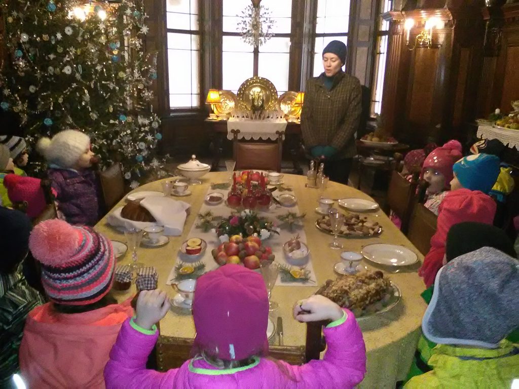 Děti u vánočně prostřeného stolu.