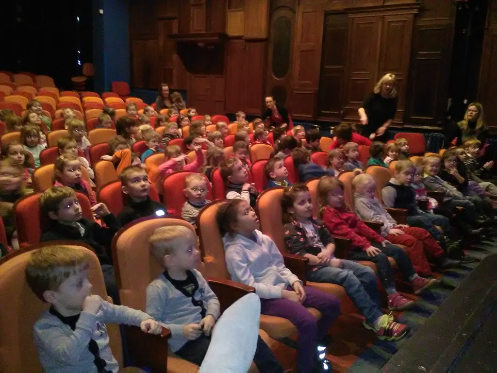 Děti sedí v divadle.