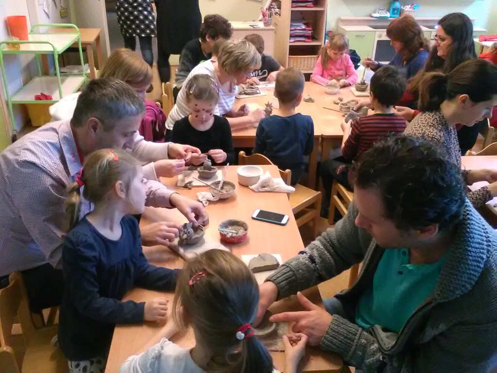 Děti s rodiči tvoří výrobky z keramiky.