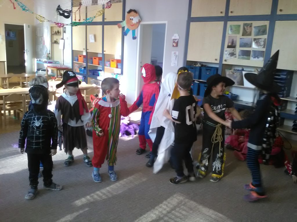 Děti v kostýmech tančí.