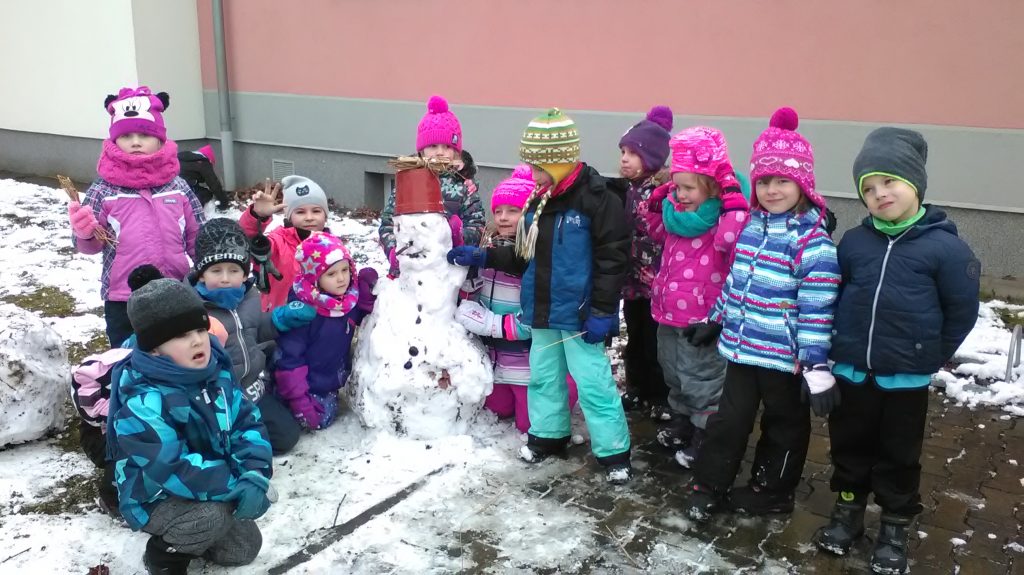 Děti se fotí se sněhulákem.