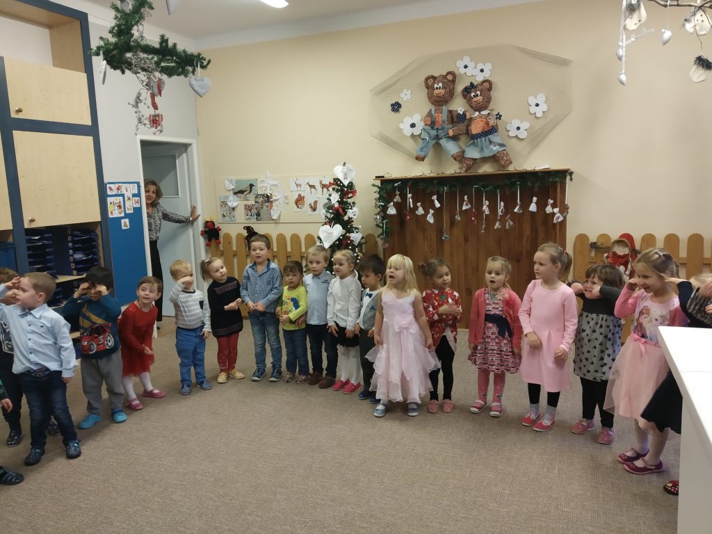 Děti stojí a zpívají na vánoční besídce.
