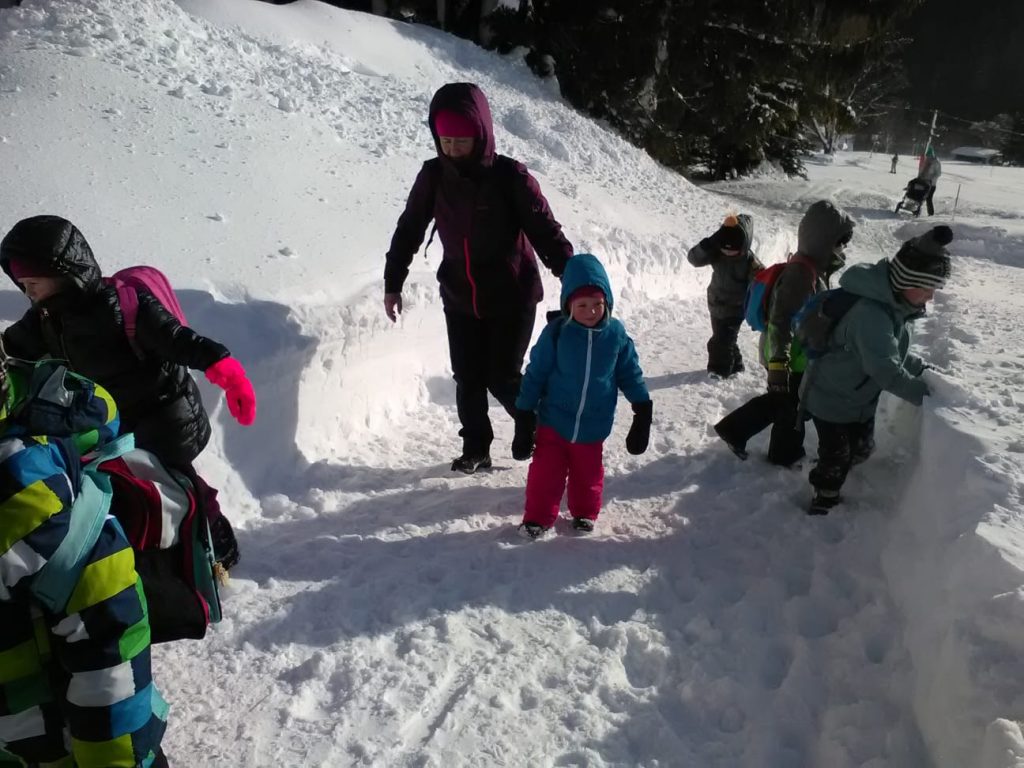 Děti jdou ve sněhu.