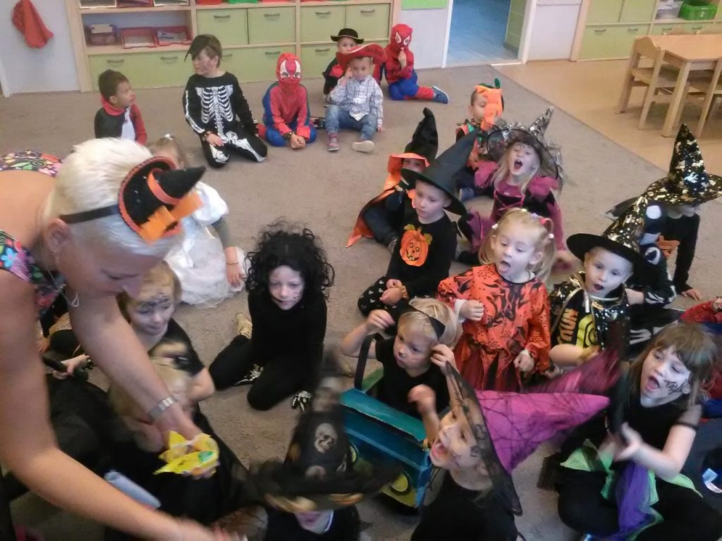Děti mají halloweenské kostýmy a dostávají bonbóny.