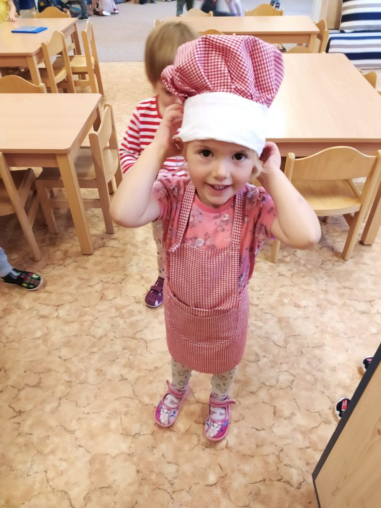 Holčička je oblečená jako kuchařka.