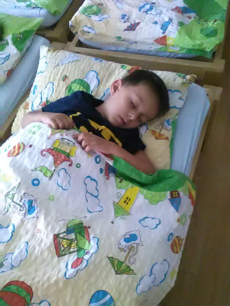 Chlapeček spí v postýlce.