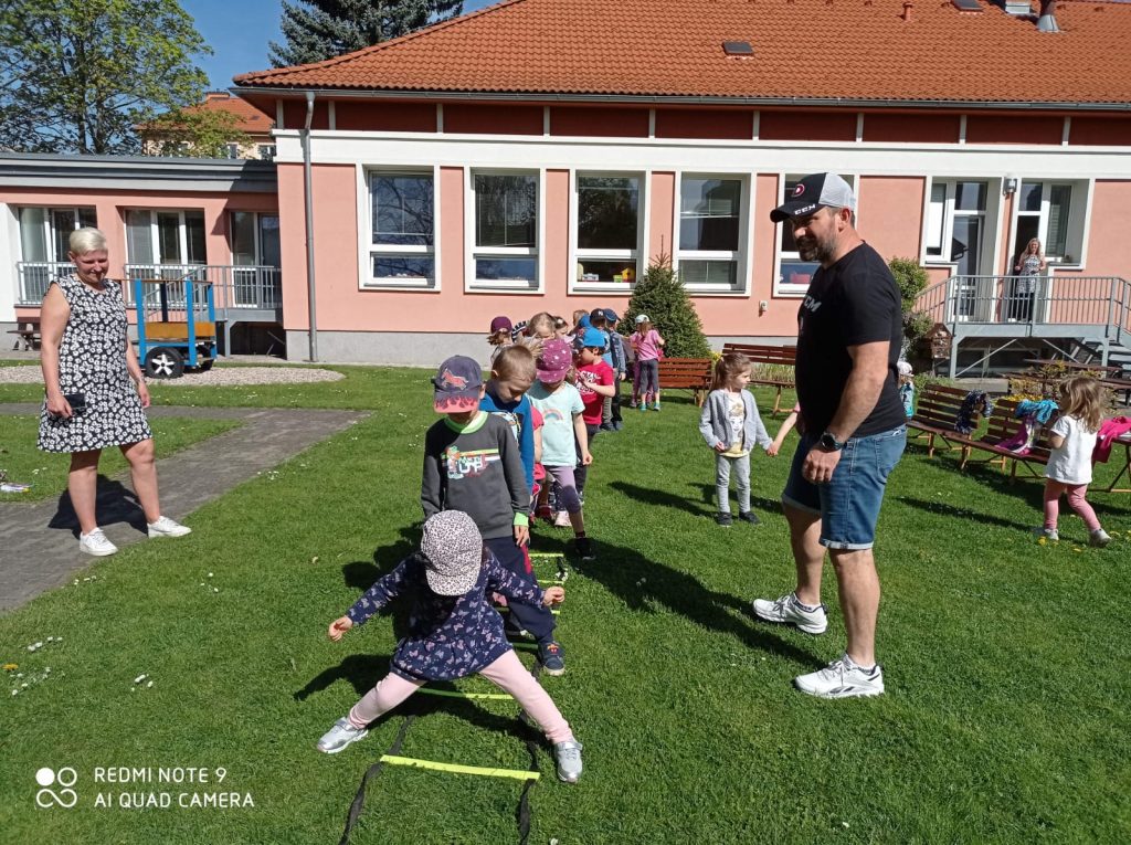 Děti cvičí na zahradě mateřské školy.