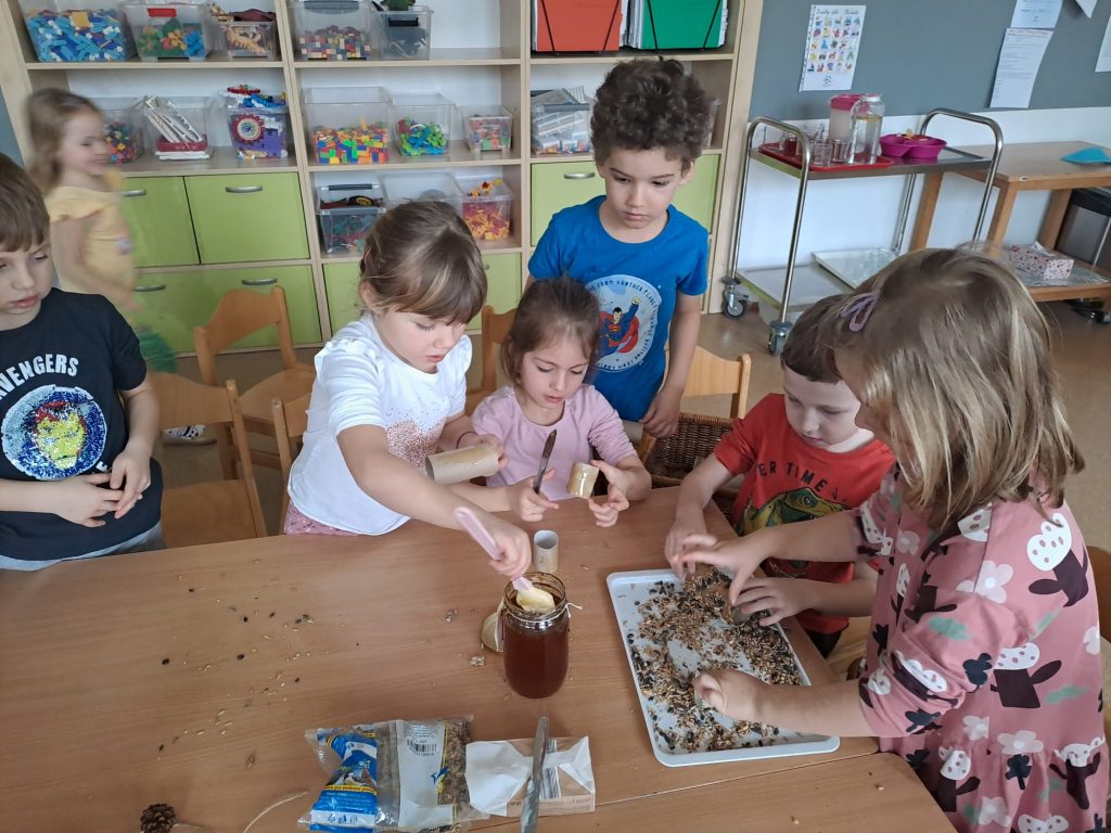 Děti vyrábí hostinu pro ptáčky.