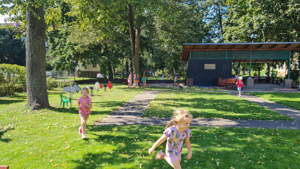 Děti si hrají na zahradě mateřské školy.