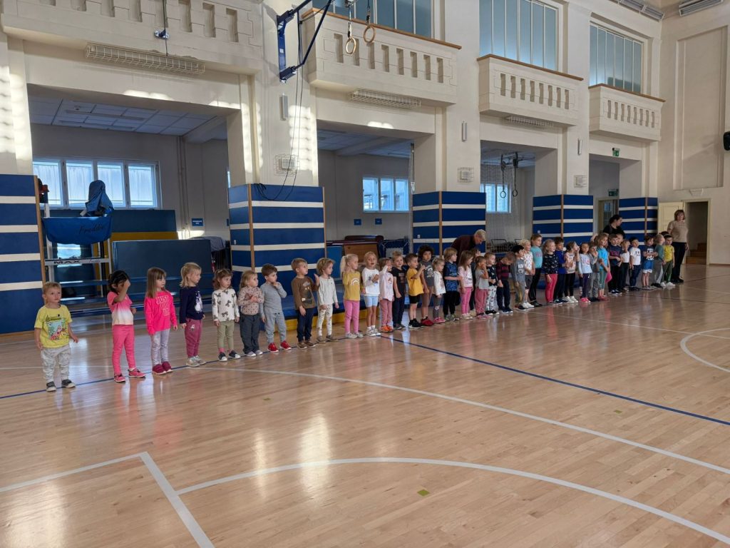 Děti stojí v sokolovně.