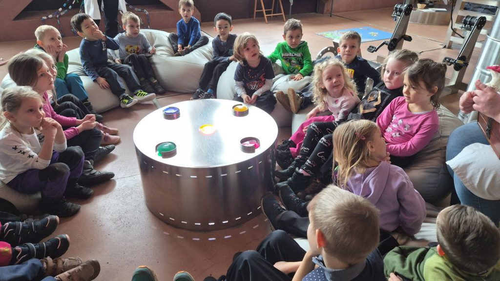 Děti sedí a poslouchají.